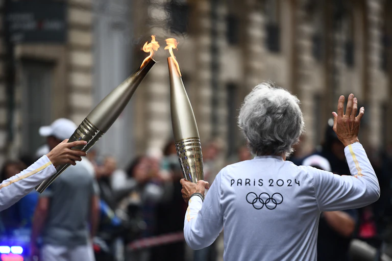 femme de dos portant la flamme olympique avec une autre personne à bordeaux