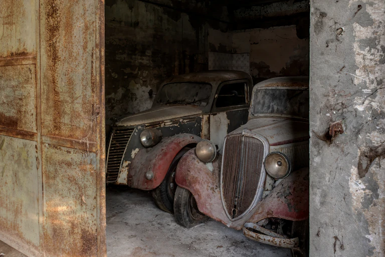 Un vieux garage avec des voitures abandonnées