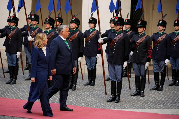 Viktor Orban e Giorgia Meloni passam por soldados do lado de fora do Palácio Chigi, em Roma.