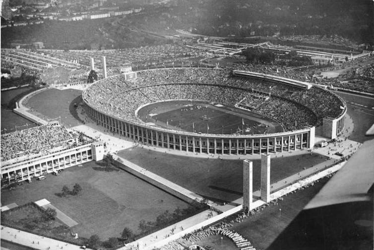 Uma fotografia de arquivo em preto e branco de um estádio cheio de espectadores.