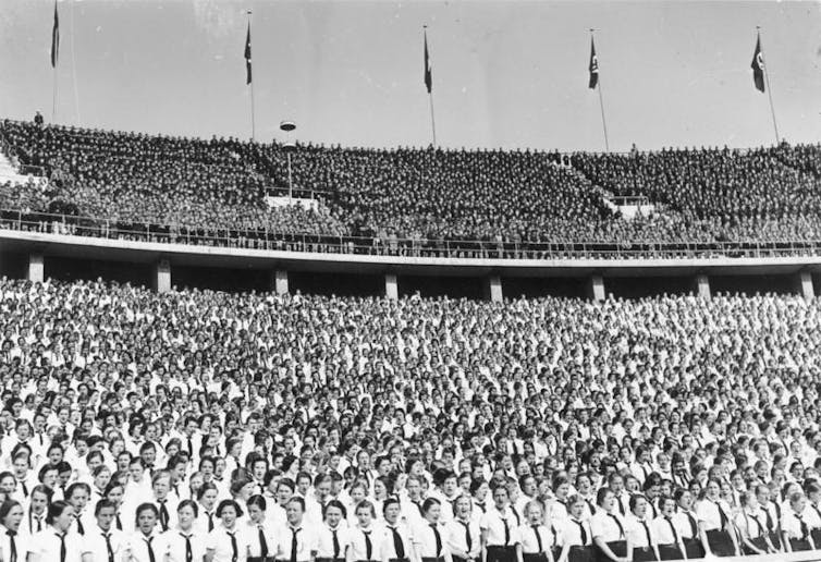 An archival photographer of Nazi supporters in a stadium.