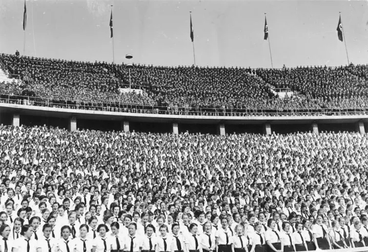 An archival photographer of Nazi supporters in a stadium.