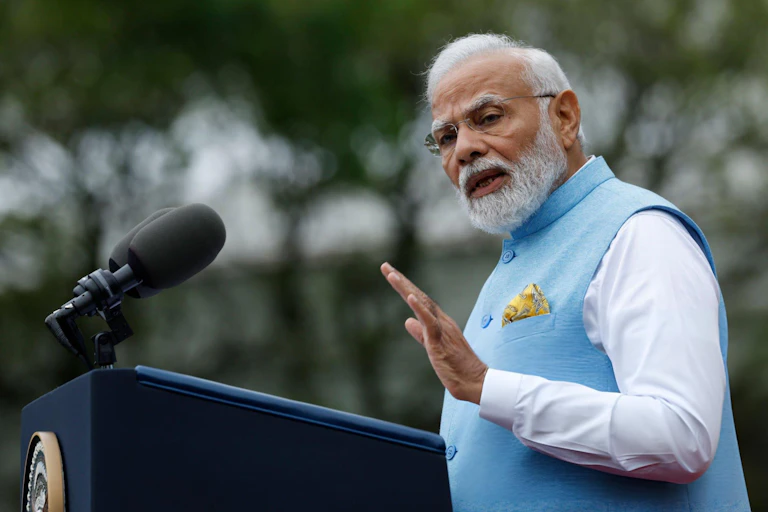 Modi delivering a speech in a blue waistcoat.