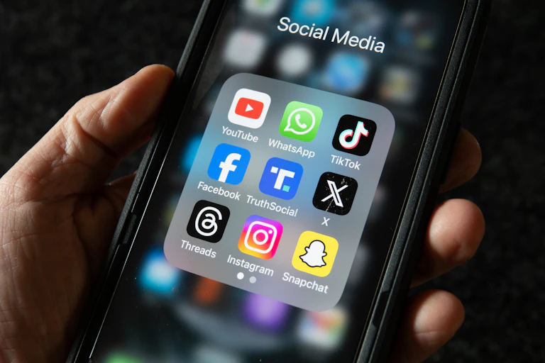 hand holding a smart phone displaying nine app icons