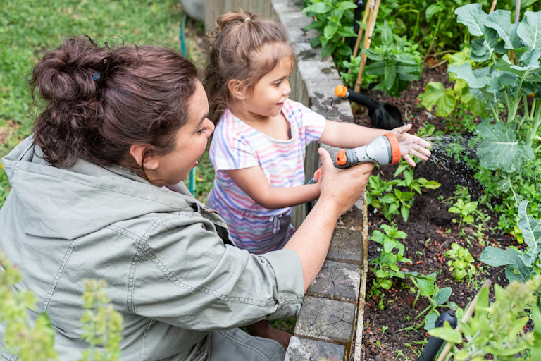 Indigenous mum gardening with young daughter