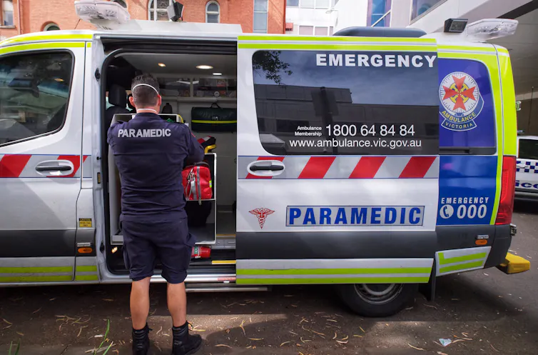 A paramedic standing outside an ambulance.