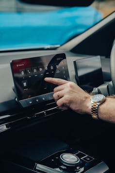 男子控制电动汽车的仪表板。