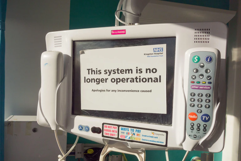 Bedside NHS phone and entertainment system with an out of order notice on it