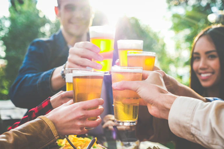 Des jeunes gens trinquent et s'apprêtent à boire des quantités importantes de bière.