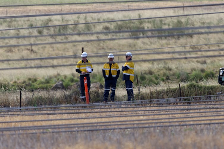 workers behind transmission lines
