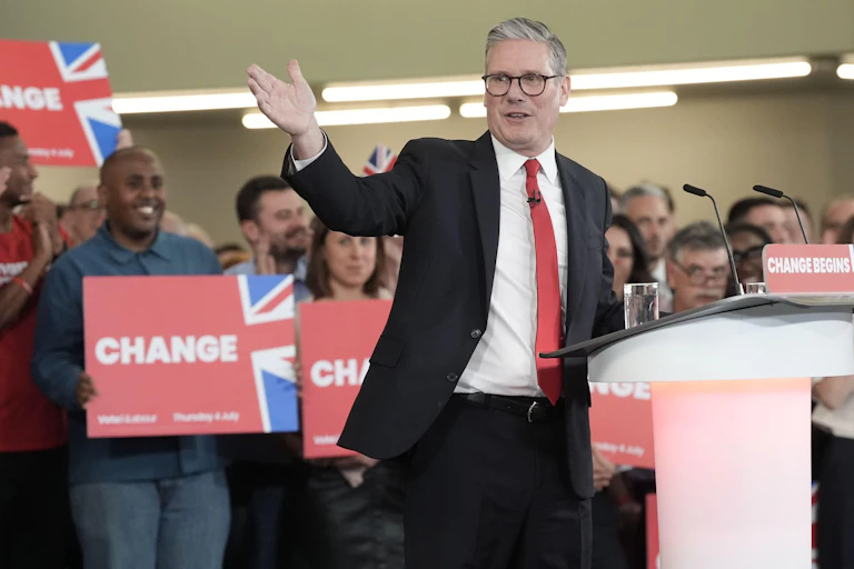 Keir Starmer standing at a lectern with activists behind him
