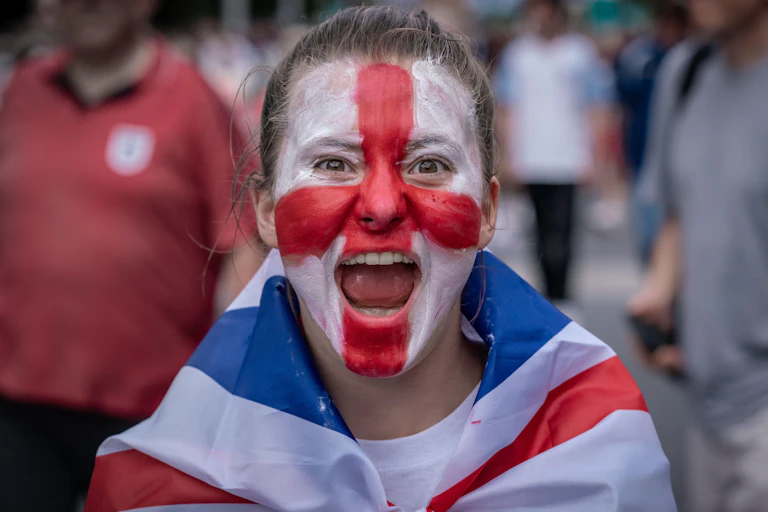 A young woman football fan with the England flag painted on her face.