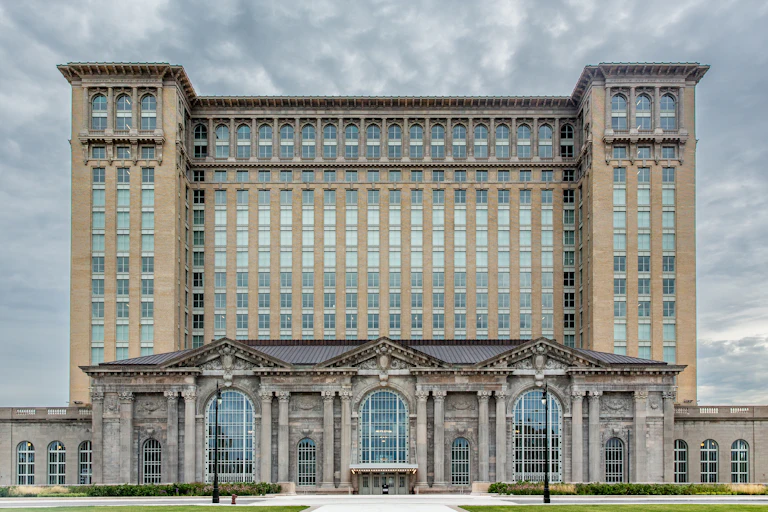Large building with windows stands against gray sky.