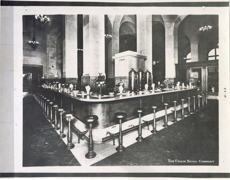 Black and white photo of a lunch counter in the Michigan Central Station Depot featuring stools and a bar.
