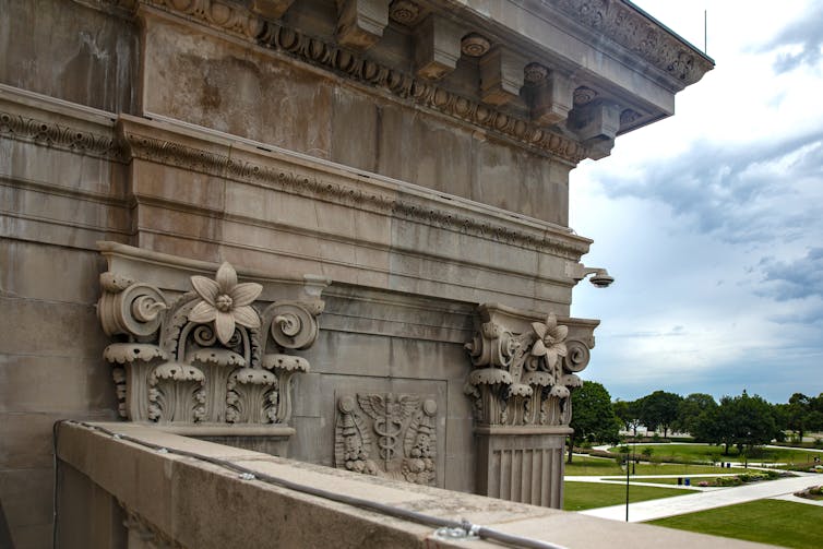 Ornate carved limestone high above an open park area.