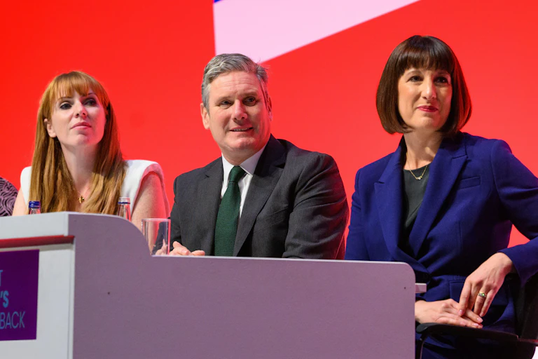Angela Rayner, Keir Starmer and Rachel Reeves sit side by side on stage at the Labour conference in October.
