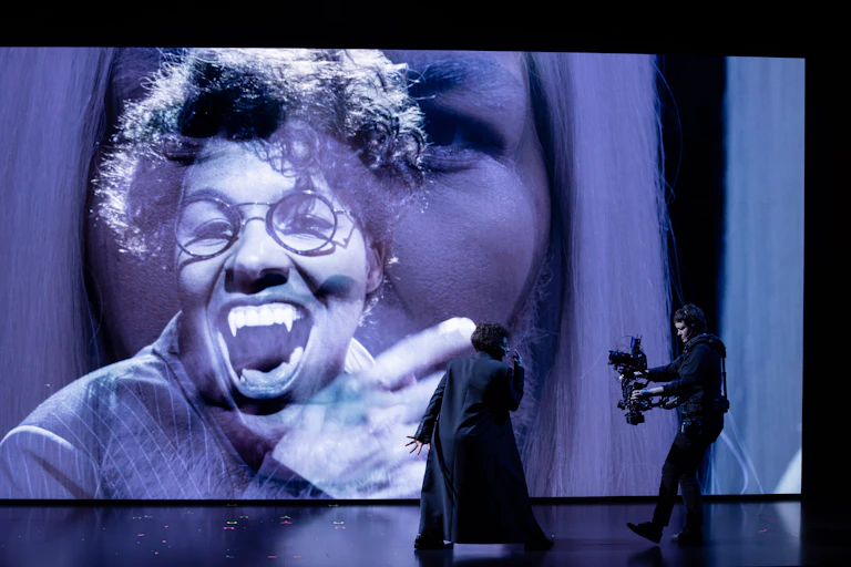 Production image: a large Dracula projection, an actor and a camera man.