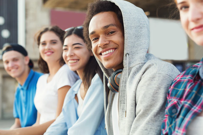 group on young people sitting outside and smiling