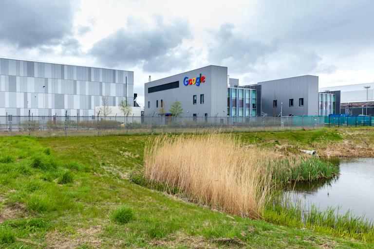 Photo of a large blocky grey building with the Google logo on it.