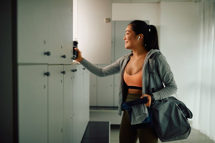 A young woman smiling in a gym change room.