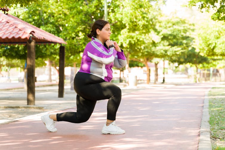A woman doing a lunge outdoors.