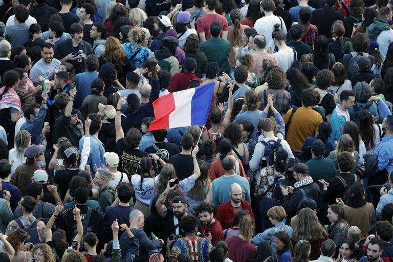 Une foule de personnes brandissant un drapeau français