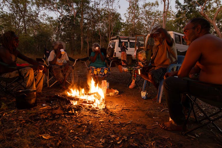 people sitting around a campfire