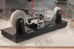 Reproduction d’une machine de Turing. Un long ruban, enroulé de chaque côté, passe sous la tête de lecture/écriture