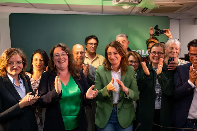 Green party members smiling and clapping.