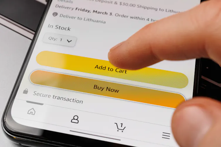 finger hovers above 'buy now' button on an online store seen on a phone screen