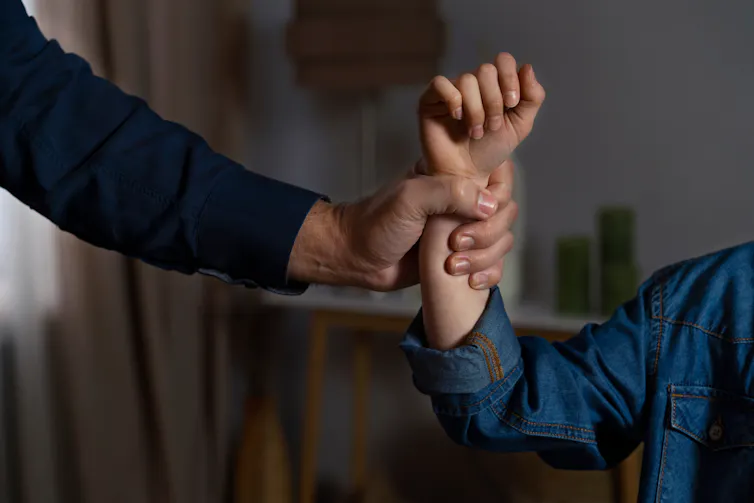 Man's hand grabs woman's wrist