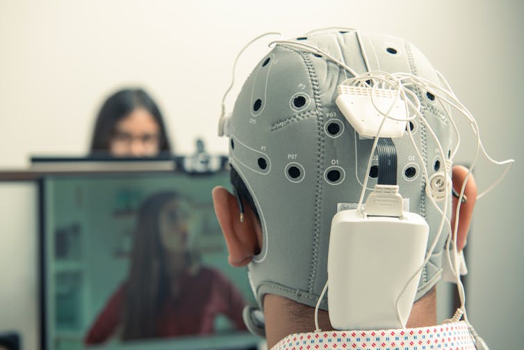 Back of man's head wearing EEG scanner