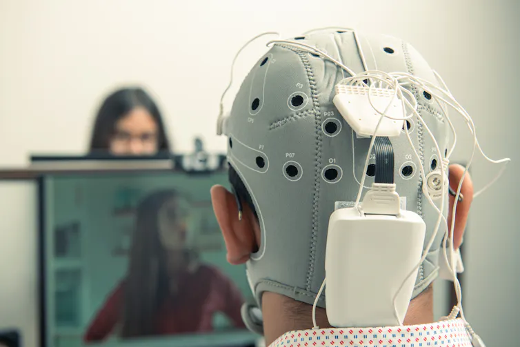 Back of man's head wearing EEG scanner