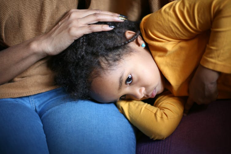 A child's head resting on an adult's lap.
