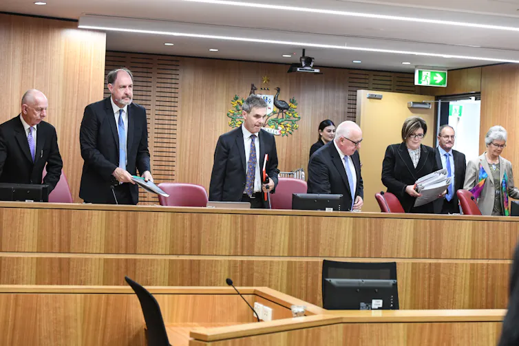 Men and women standing at a tribunal