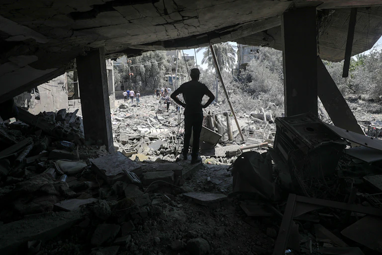 A man inspects the rubble of a destroyed building following an Israeli air strike.