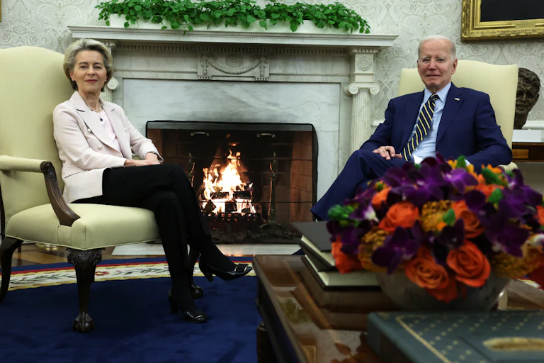 Ursula van der Leyer et Joe Biden devant un feu de bois dans une maison