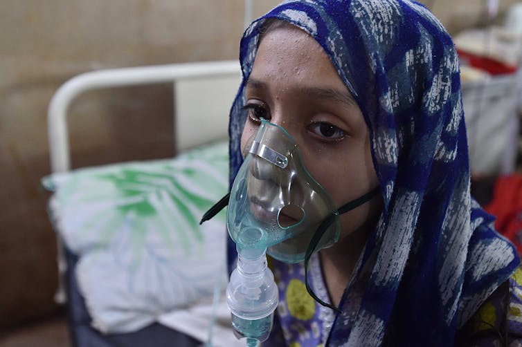 A woman wearing a breathing mask in hospital.