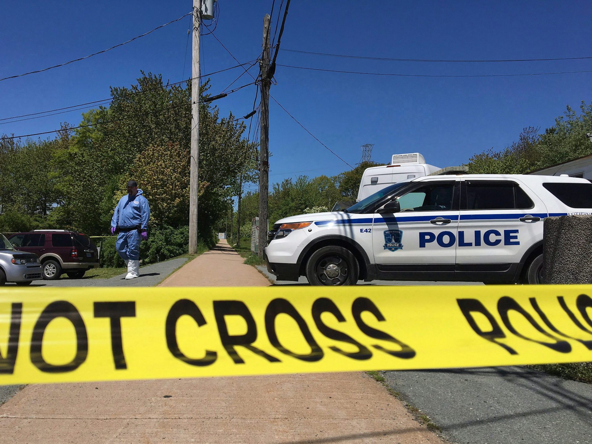 Yellow police tape in front of a police cruiser.