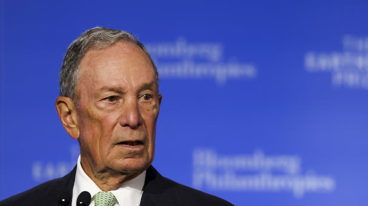 Photo of Mike Bloomberg speaking into a microphone.