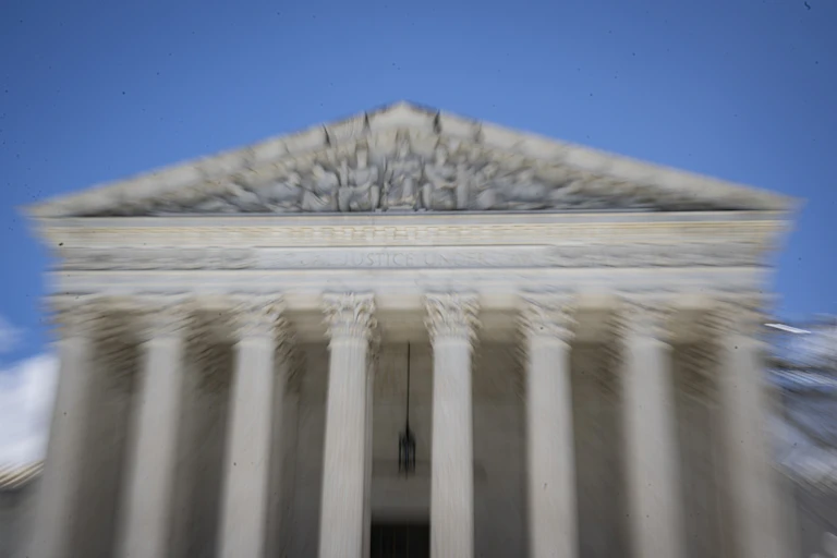 The front of the Supreme Court building is seen up close, slightly blurred.