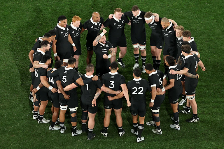 All Blacks players in a circle on the field