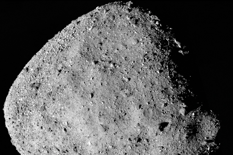 Uma grande rocha acizentada iluminada da lado sobre o fundo escuro do espaço
