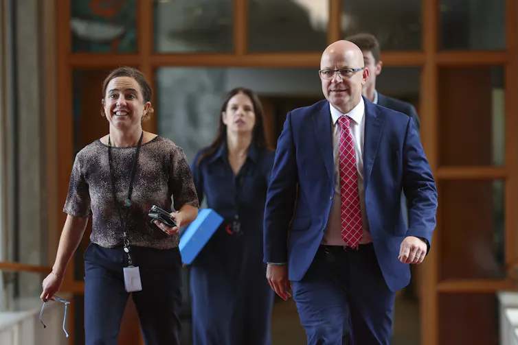 Minister Matt Doocey and a colleague walking down a hallway
