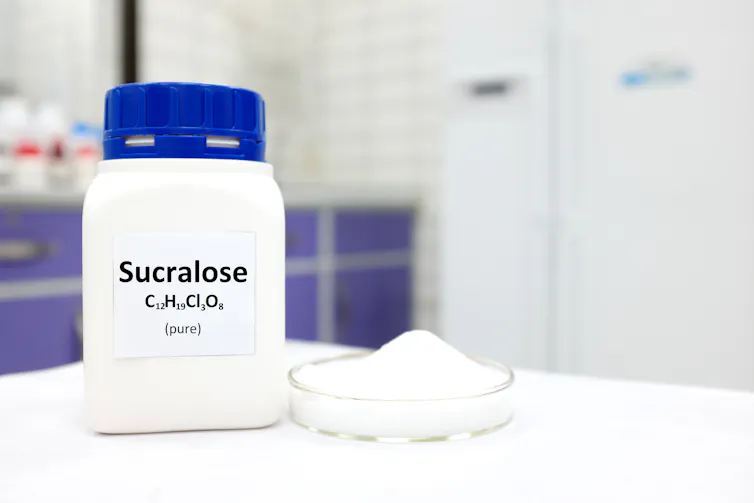 lab shot of white container with blue lid, label says sucralose with chemical name