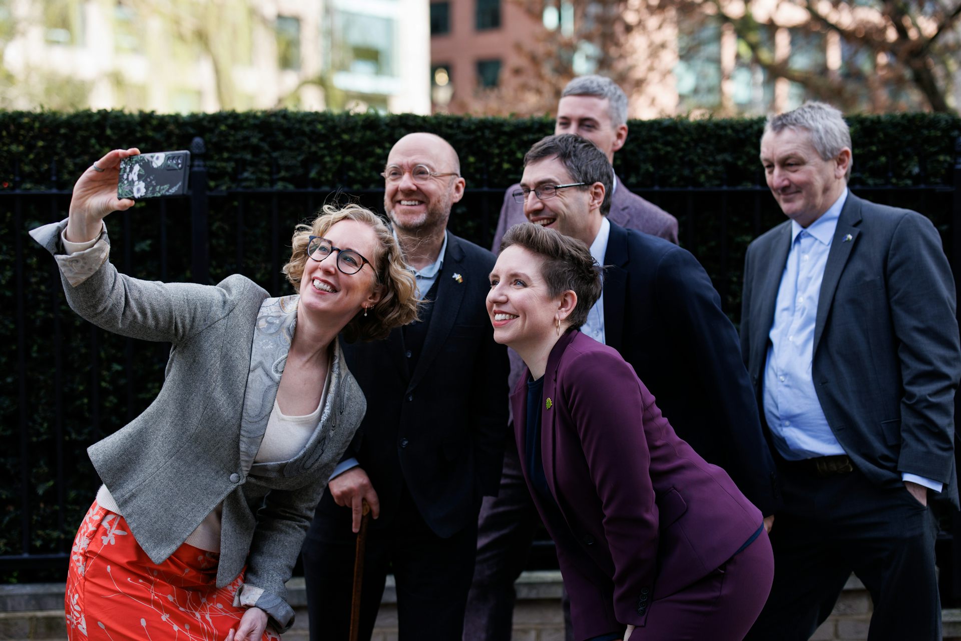 Politicians in suits gather for a selfie.