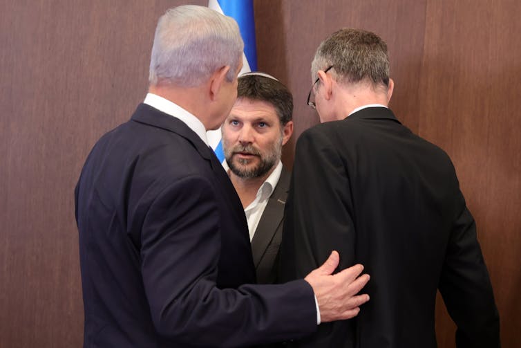 Smotrich speaking with Netanyahu, who has his back turned.