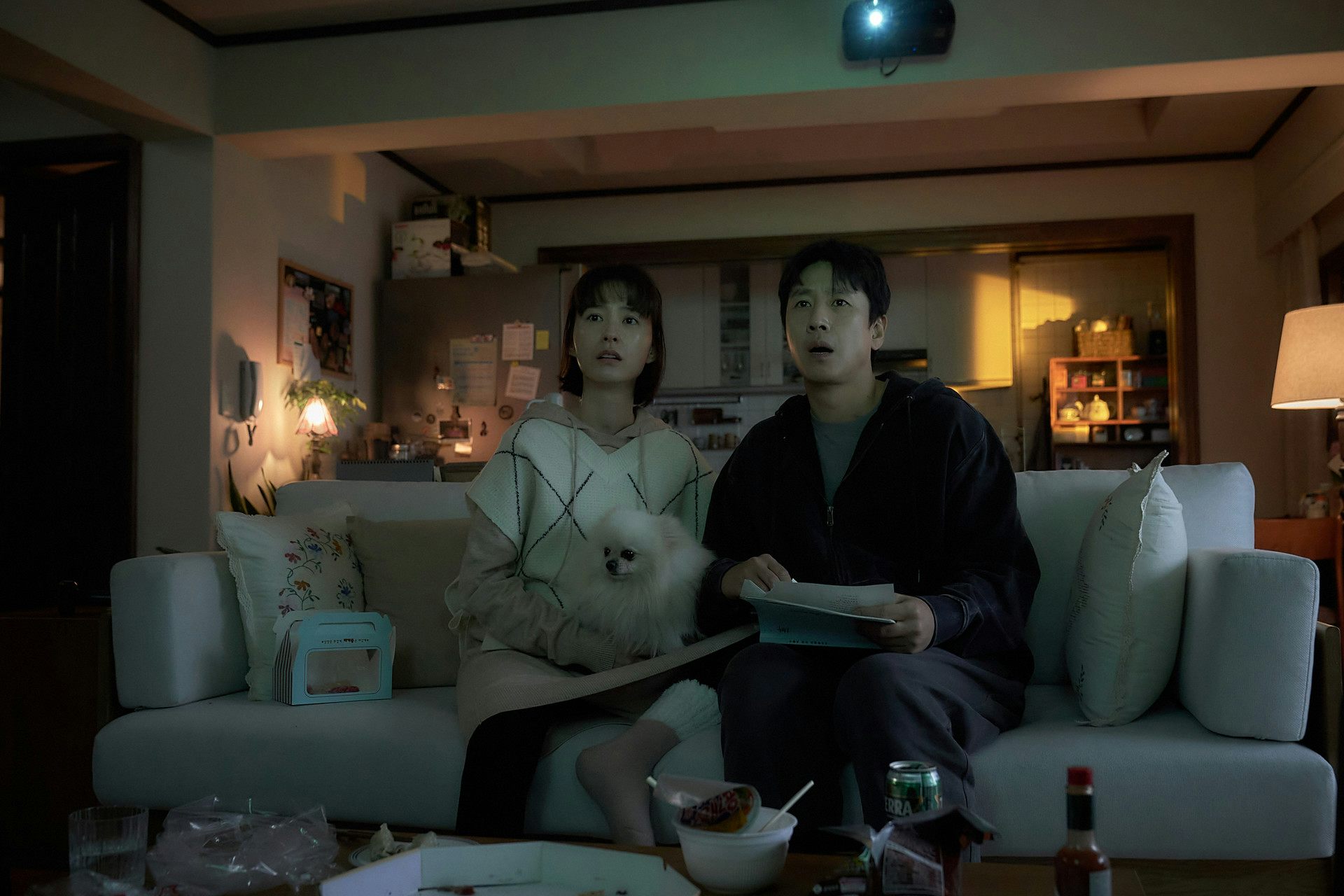 Soo-jin and Hyun-su sitting on the sofa with their dog