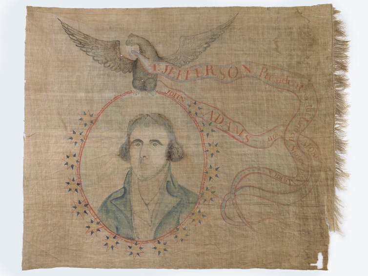 A brown linen banner with a painting of a man surrounded by an oval and an eagle above him.