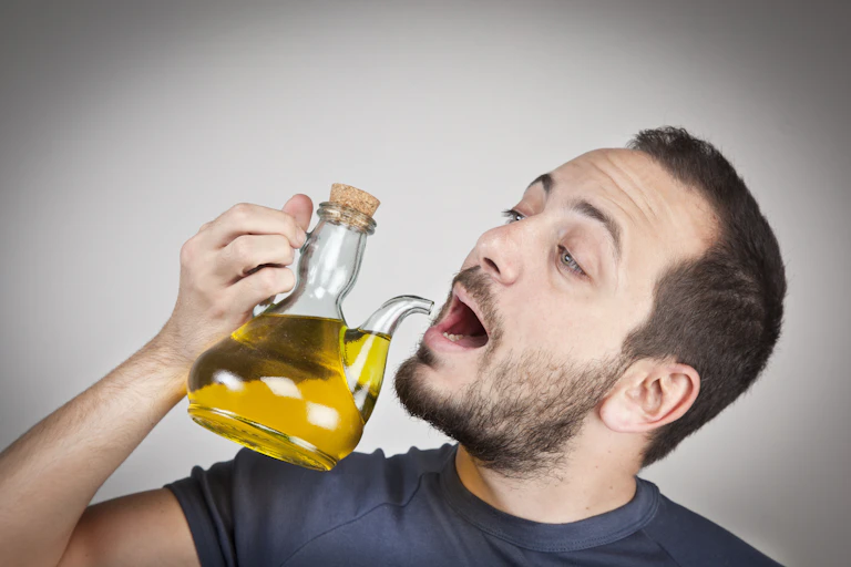 Man drinking olive oil